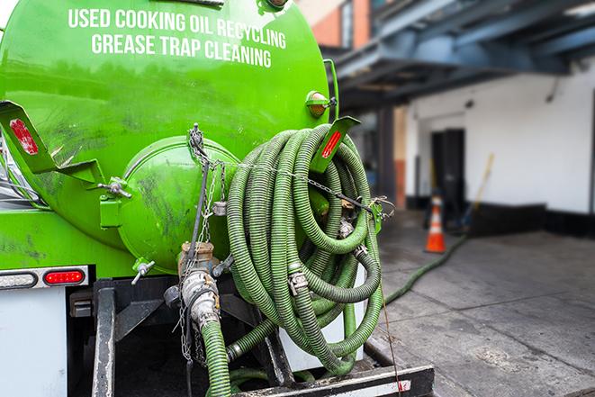 a technician pumping a grease trap in a commercial building in East Rutherford NJ